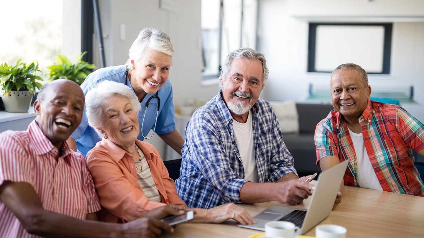 five older adults looking a a computer